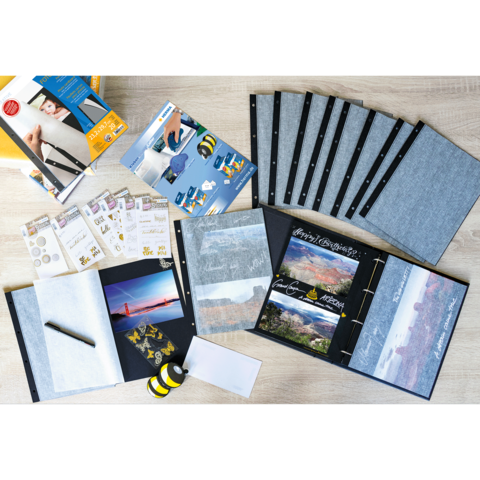 Ein Scrapbook-Set mit leeren Seiten, Aufklebern, einem Stift und verschiedenen Zubehörteilen zum Gestalten von Fotoalben.
