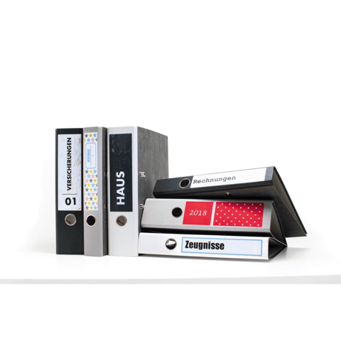 Eine Gruppe von Ordnern in verschiedenen Farben, beschriftet mit "Versicherungen", "Haus", "Rechnungen" und "Zeugnisse".